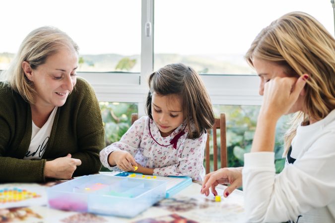 Woman playing board game with daughter and granddaughter