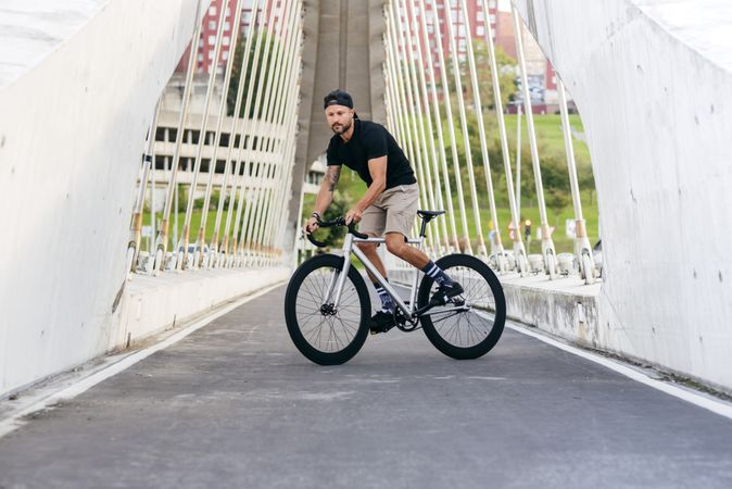 Man riding a bicycle on footbridge