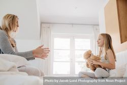 Mother and daughter playing with teddy bear on bed at home bepm34