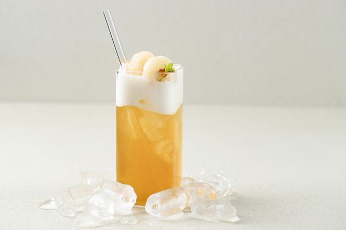 Refreshing ice tea topped with foam with straw