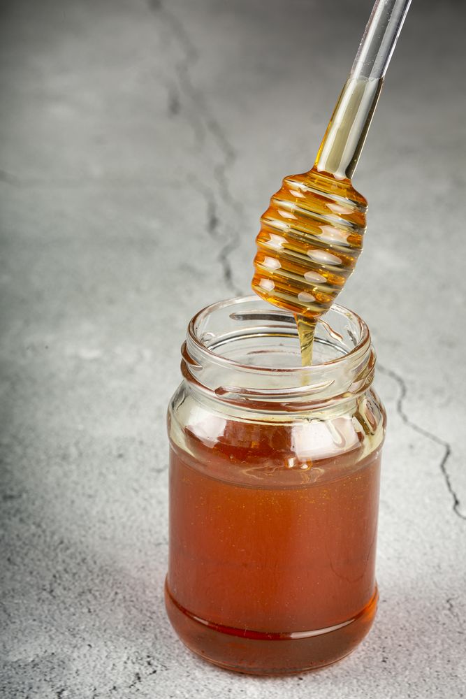 Honey in glass jar on the table.