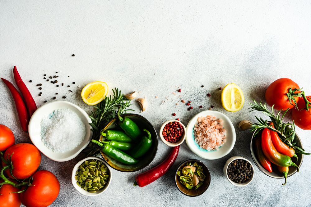 Top view of seasoning with tomatoes, garlic & herbs on counter with copy space
