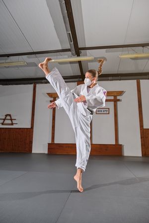 Woman in kimono performing Krav Maga punch