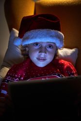 Little boy in Christmas clothes using tablet