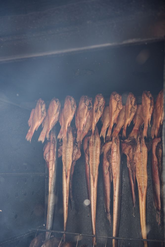 Row of smoked fish on wooden rail
