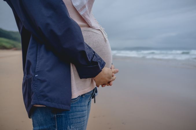 Pregnant woman standing on beach