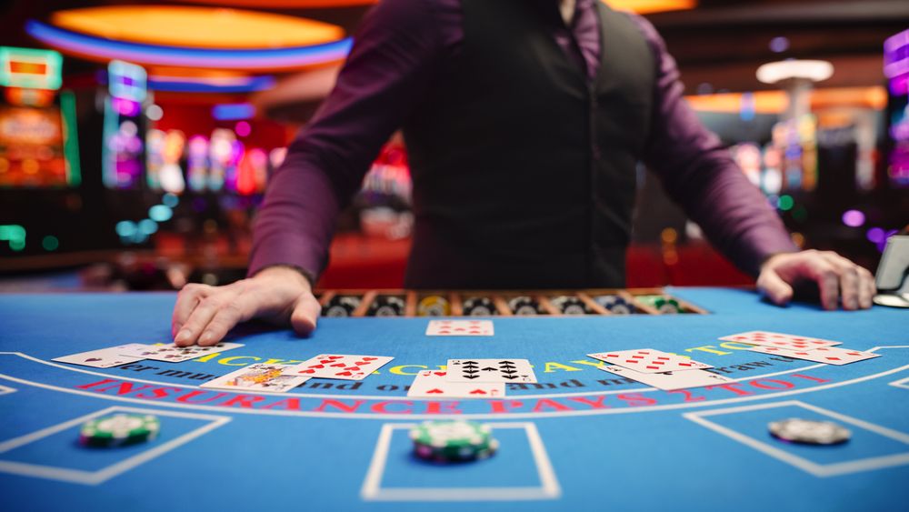 Online Casino: Professional Croupier Deals Cards on Blackjack Table: Anonymous Male Game Dealer Masterfully Revealing possible Jackpot Winning Hand