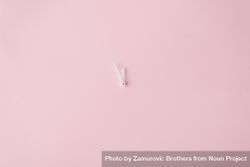 Clock hands on pastel pink painted wall 4dqadb