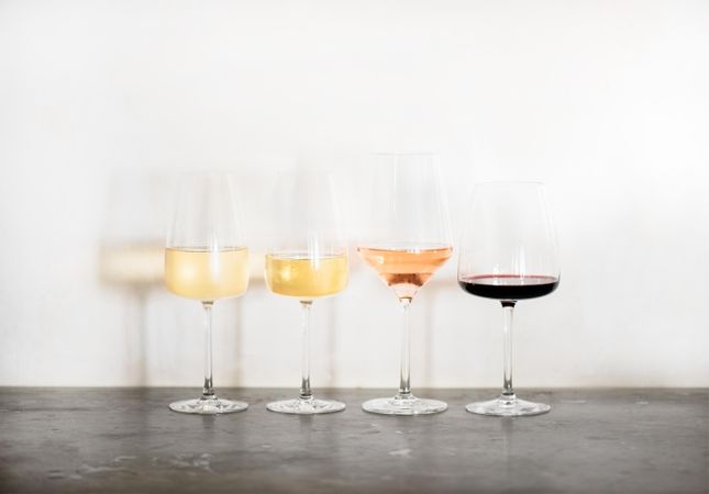Wine flight of 4 types of wine, from light to dark, in different shaped glassware, copy space