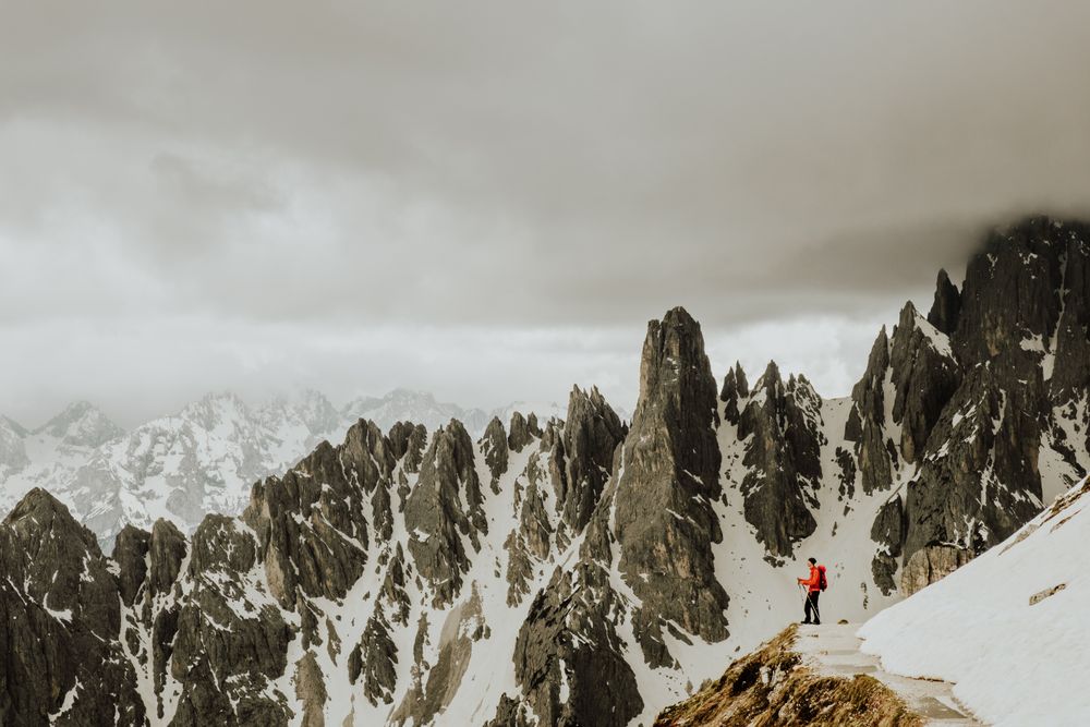 Person in red jacket standing on snow covered mountain