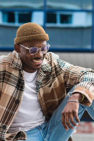Stylish Black man resting on street