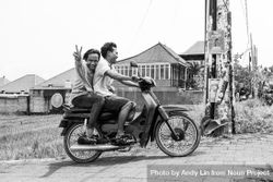 Bali, Indonesia - Feb 25, 2018 - Men riding moped, flashing peace sign 5a9Gd5