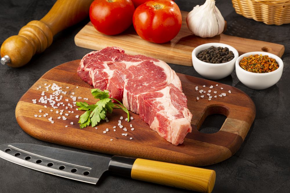 Raw ancho meat ready to roast on a wooden cutting board.