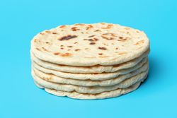 Naan bread isolated on blue background