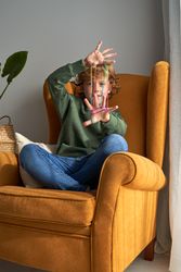 Cheerful boy playing and looking at camera through fingers