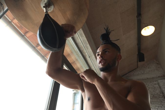 Black guy boxing in gym