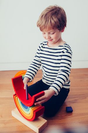Boy playing with wooden construction pieces