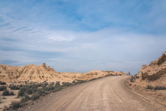 Man walking on road in desert hills