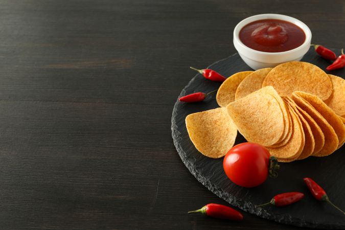Potato chips in a bowl with chili pepper and sauce