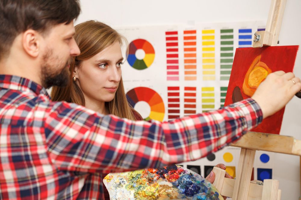 A man paints a still life with a palette knife and oil paints