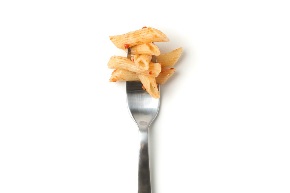 Fork with tasty pasta isolated on plain background