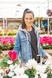 Smiling Hispanic woman choosing potted flowers