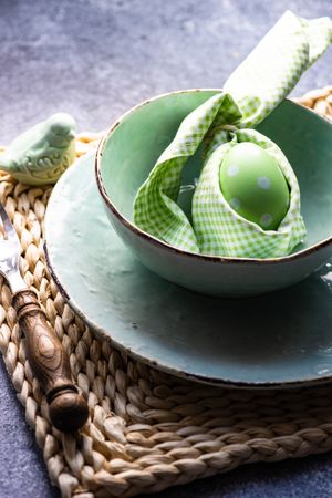 Easter holiday table setting with pastel egg wrapped in napkin