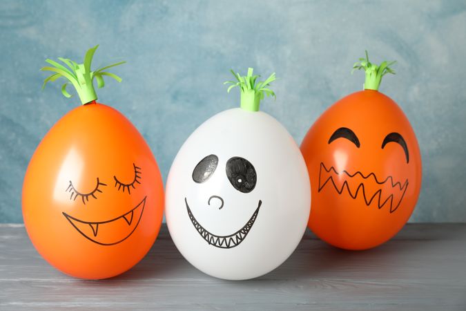 Funny pumpkins on grey wooden background, space for text