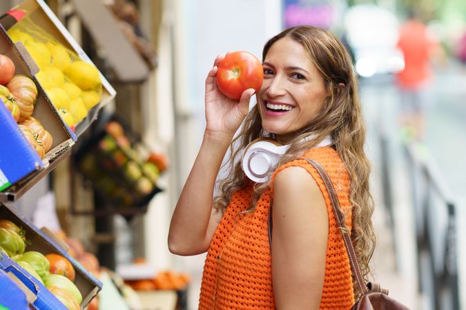 Woman holding organic delicious tomato shopping at organic food market