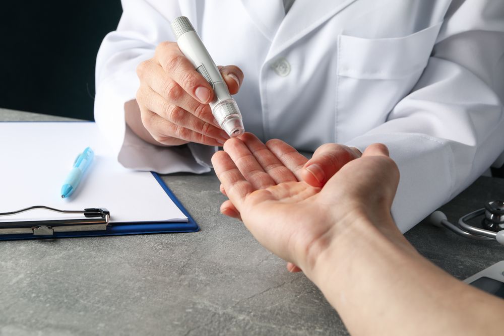 Doctor checking blood sugar level in patient diabetes on gray table