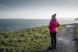 Woman standing on country road admiring views