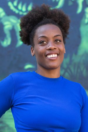 Black woman standing near wall with graffiti