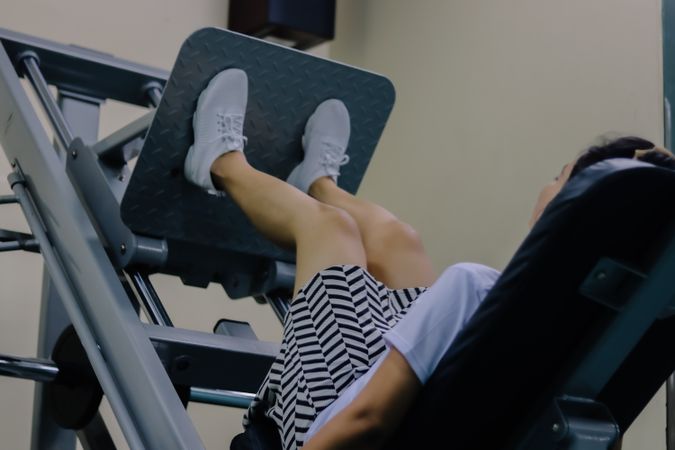 women using the leg press machine are wearing shoes, shorts and a shirt
