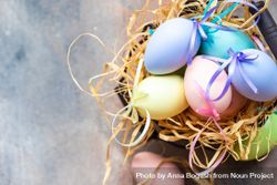 Top view of decorative Easter eggs in straw on table with copy space 5wXLkW