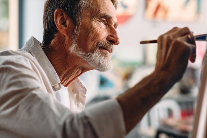 Older man painting in studio