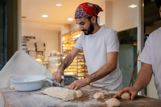 Arabic baker cutting dough with scapula
