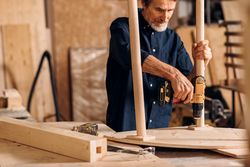 Older male building furniture with power tools