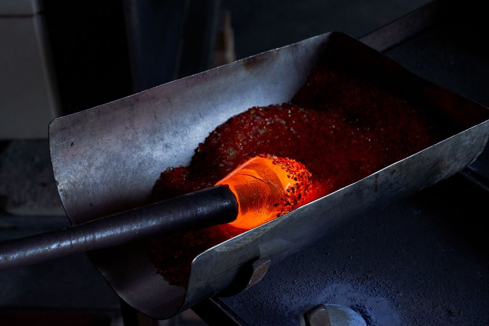 Glassblowing of hot object in workshop