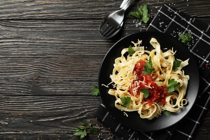 Composition with plate of tasty pasta on wooden background