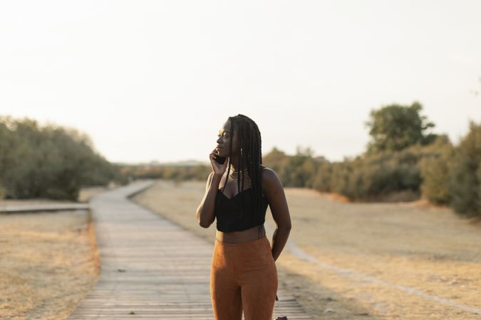 Young Black female talking on the phone in the park