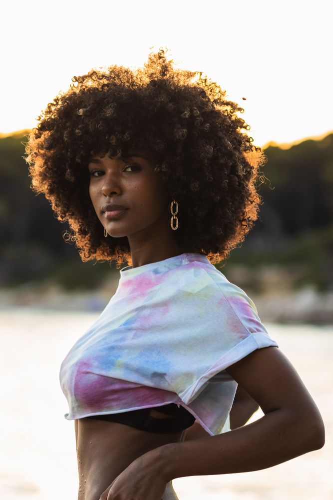 Unemotional Black woman standing on seashore