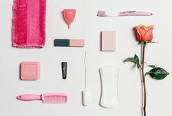 Feminine accessories in pink tones over plain background