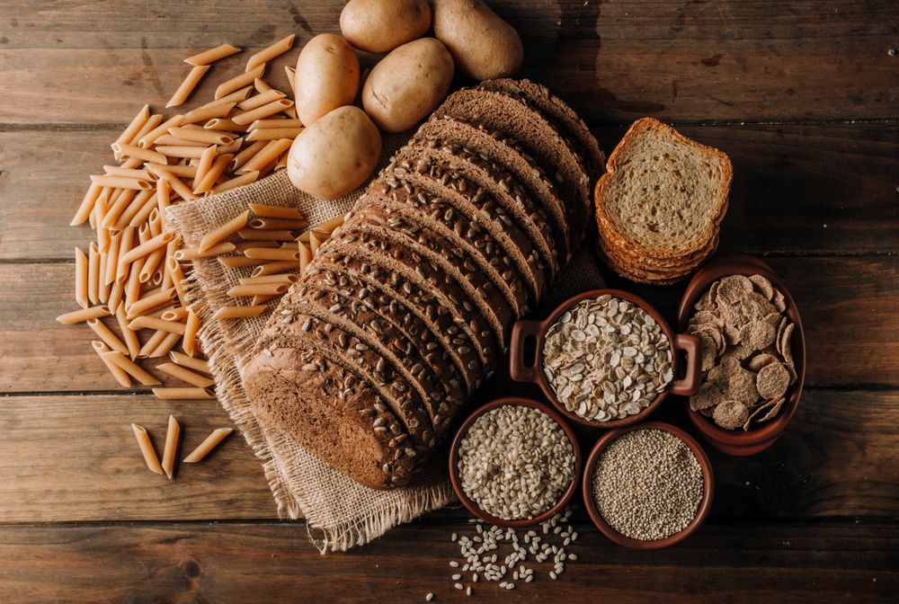 Wholegrain food pasta and freshly baked rye bread on table