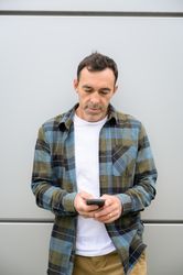 Cheerful man using smartphone in room