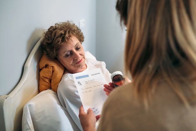 Doctor giving a prescription to older patient