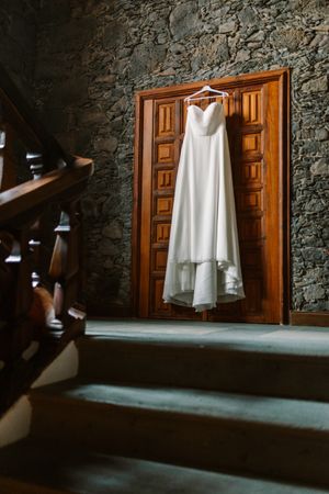 Wedding dress hanging on wooden door