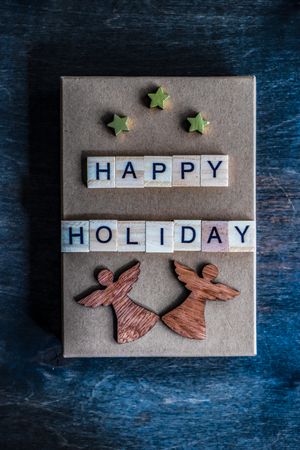 Happy holiday card with angel and stars on navy table