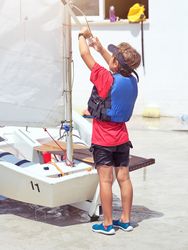 Boy preparing yacht for sailing on sunny day