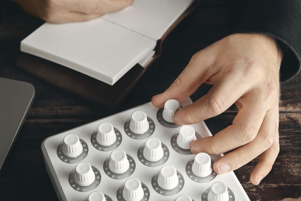 Closeup of hand twisting knob on midi mixer control