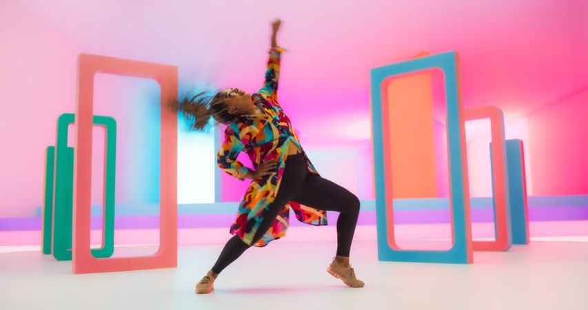 Colorful Geometric Abstract Aesthetic: Portrait of Black Woman Happily Dancing to Energetic Music in a Studio.